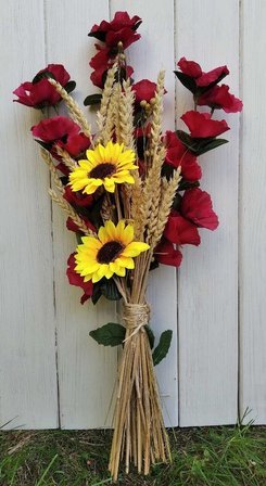A bouquet of artificial poppy flowers, sunflowers and ears of grain